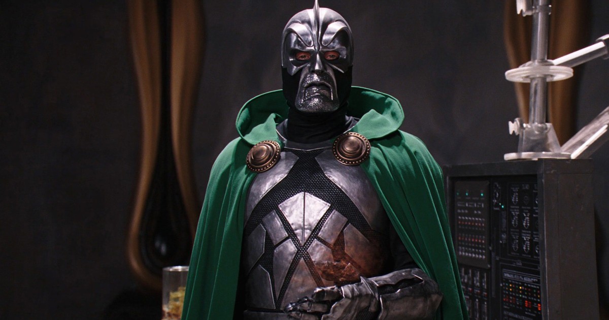 Doctor Doom in a green cloak and metal mask beside equipment in a castle laboratory